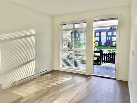 A room with a sliding glass door leading to a backyard.