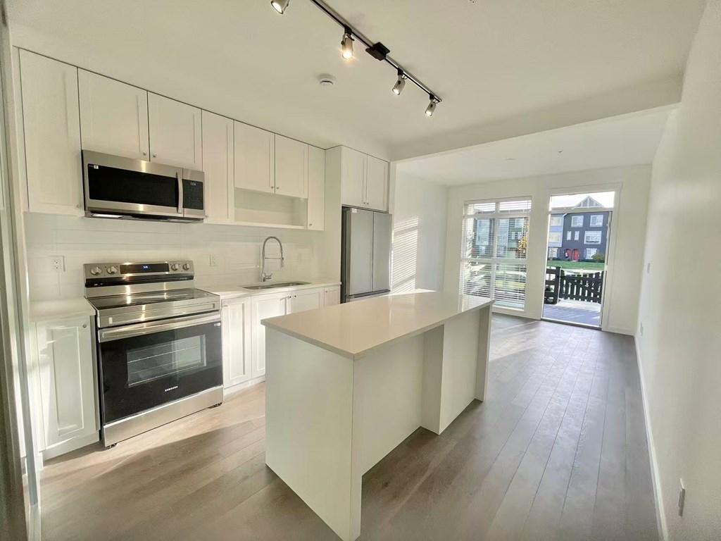 A modern kitchen with a stove top oven and microwave above it.
