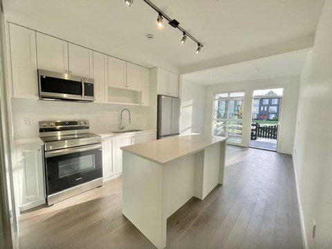 A modern kitchen with a stove top oven and microwave above it.