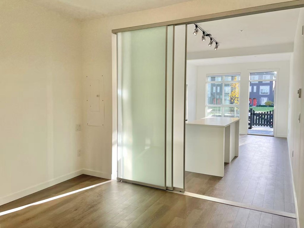 A room with a sliding glass door leading to a balcony.