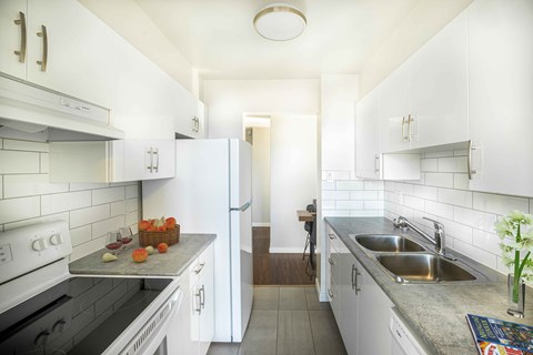 a kitchen with white cabinets and a stainless steel sink