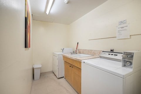 a kitchen with a washer and dryer and a sink and a stove