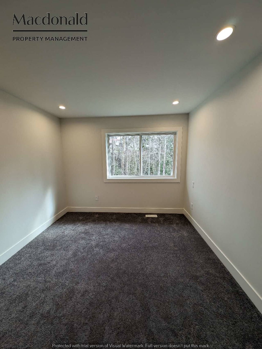 a empty room with carpet and a window