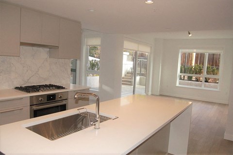 A kitchen with a stove top oven and a sink.