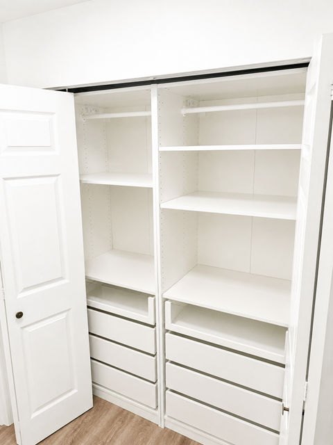 A white pantry with shelves and drawers is open.