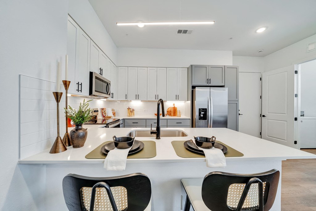 Kitchen with all stainless steel appliances and white cabinets