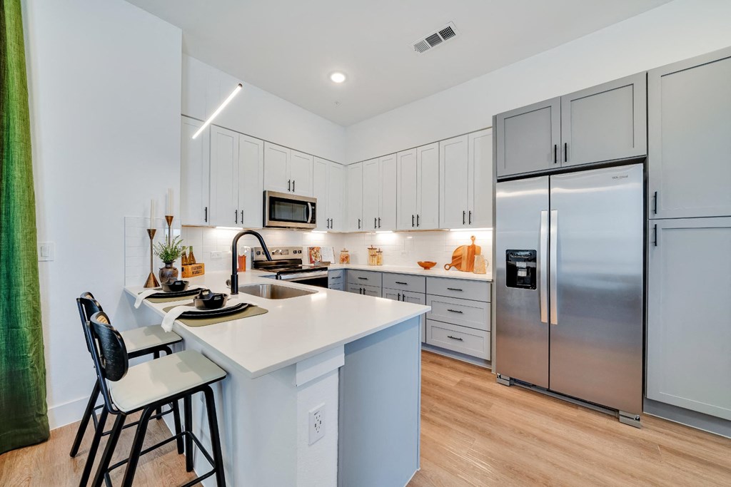 Kitchen with all stainless steel appliances and white cabinets