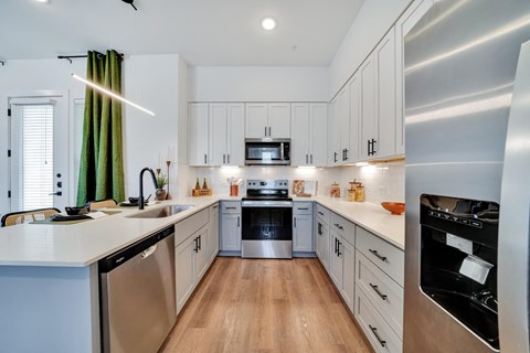 Kitchen with all stainless steel appliances and white cabinets