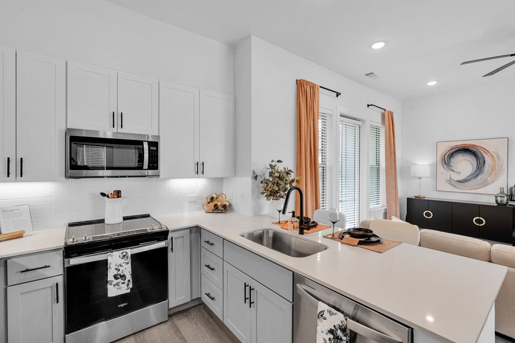 Kitchen with all stainless steel appliances and white cabinets