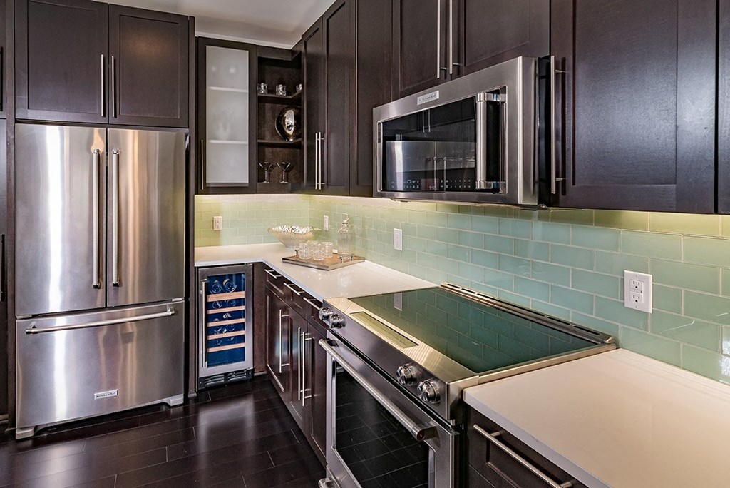 a kitchen with stainless steel appliances and black cabinets