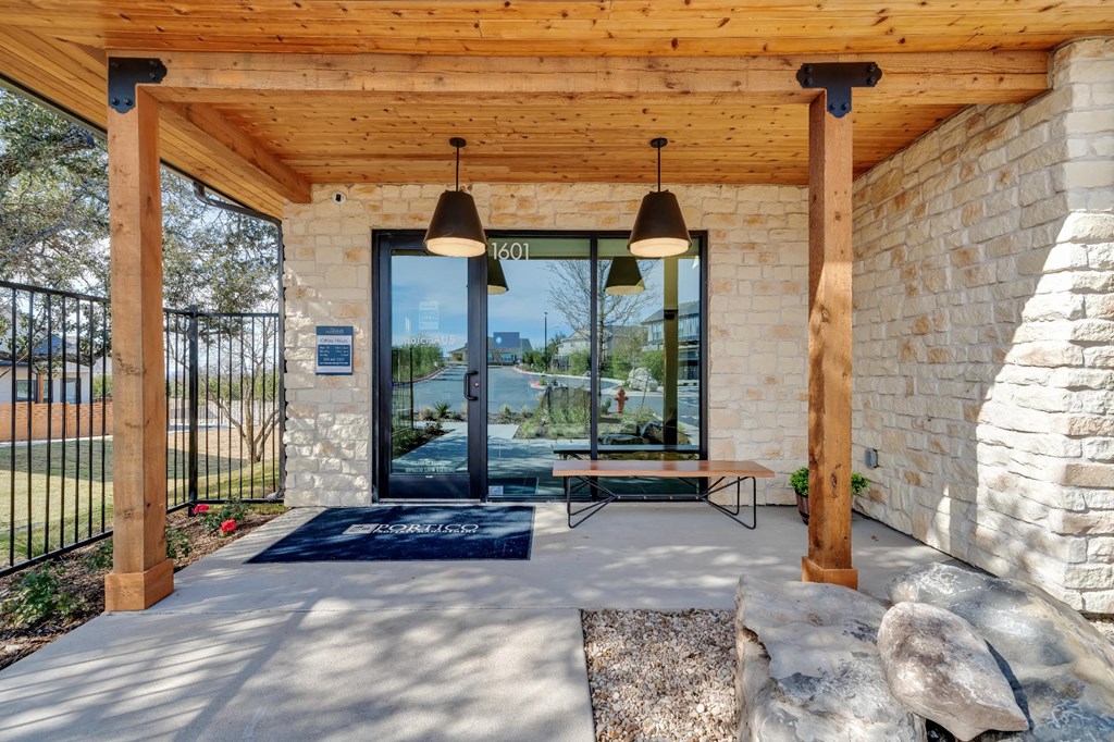 A modern house entrance with a stone wall and a glass door.