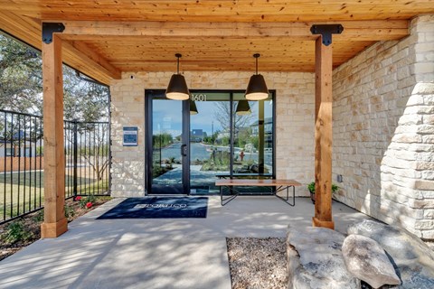 A modern house entrance with a stone wall and a glass door.