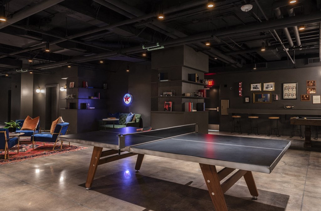 a gaming room with a ping pong table and chairs