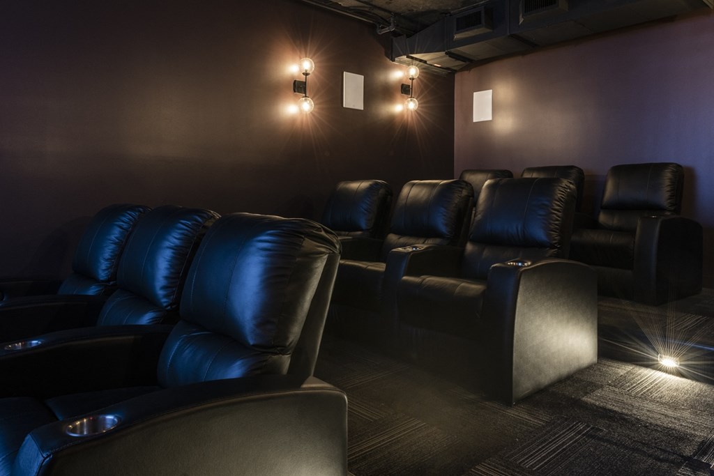 a dark screening room with leather chairs and lights