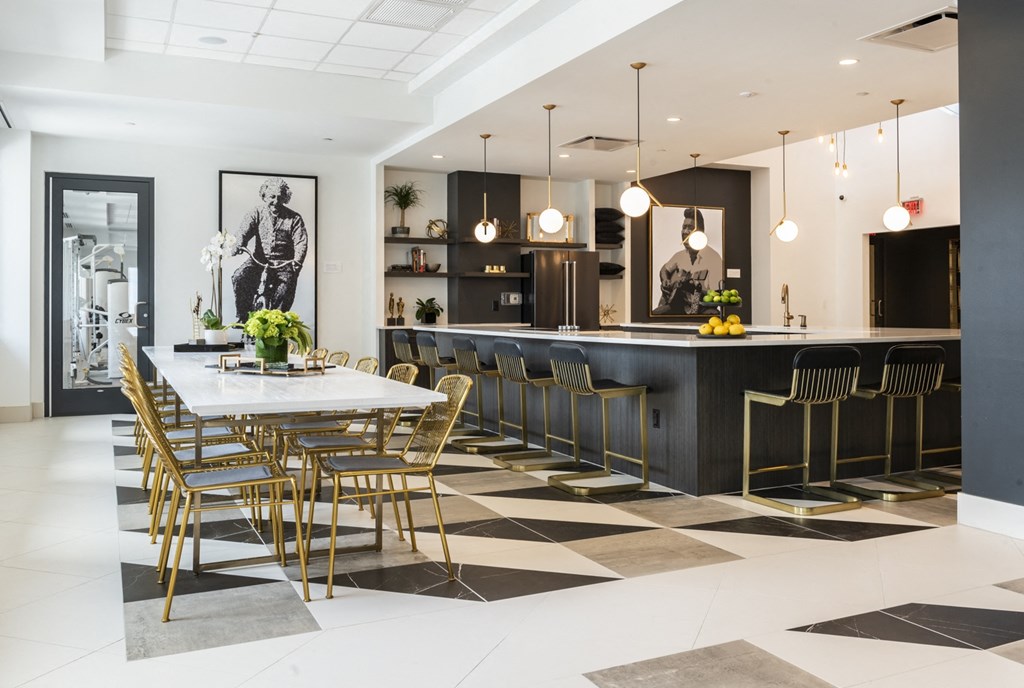 a dining room with a table and chairs and a black and white tile floor