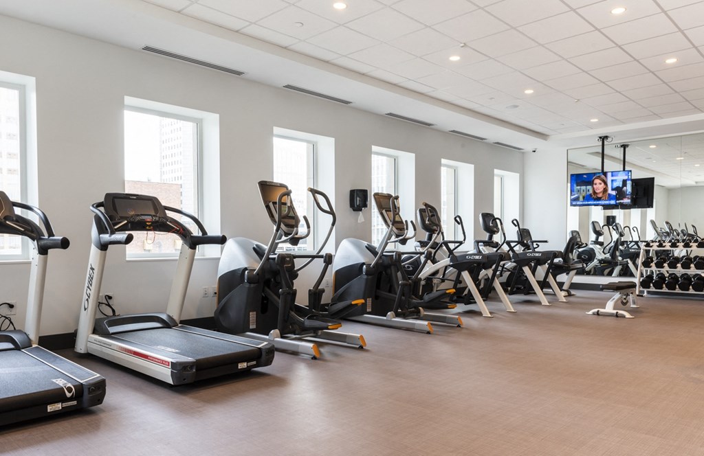 a row of cardio exercise machines in a gym