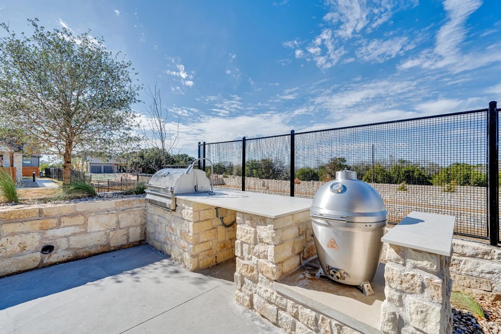 A silver dome-shaped structure sits on a stone platform with a black fence in the background.