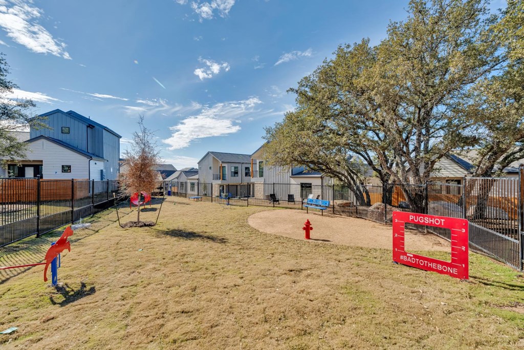 A playground with a swing set and a red sign that says "PUGSHOT" and "REALTOR OF THE BONE".