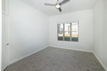 Spacious bedroom Large apartment with carpet and metal ceiling fan