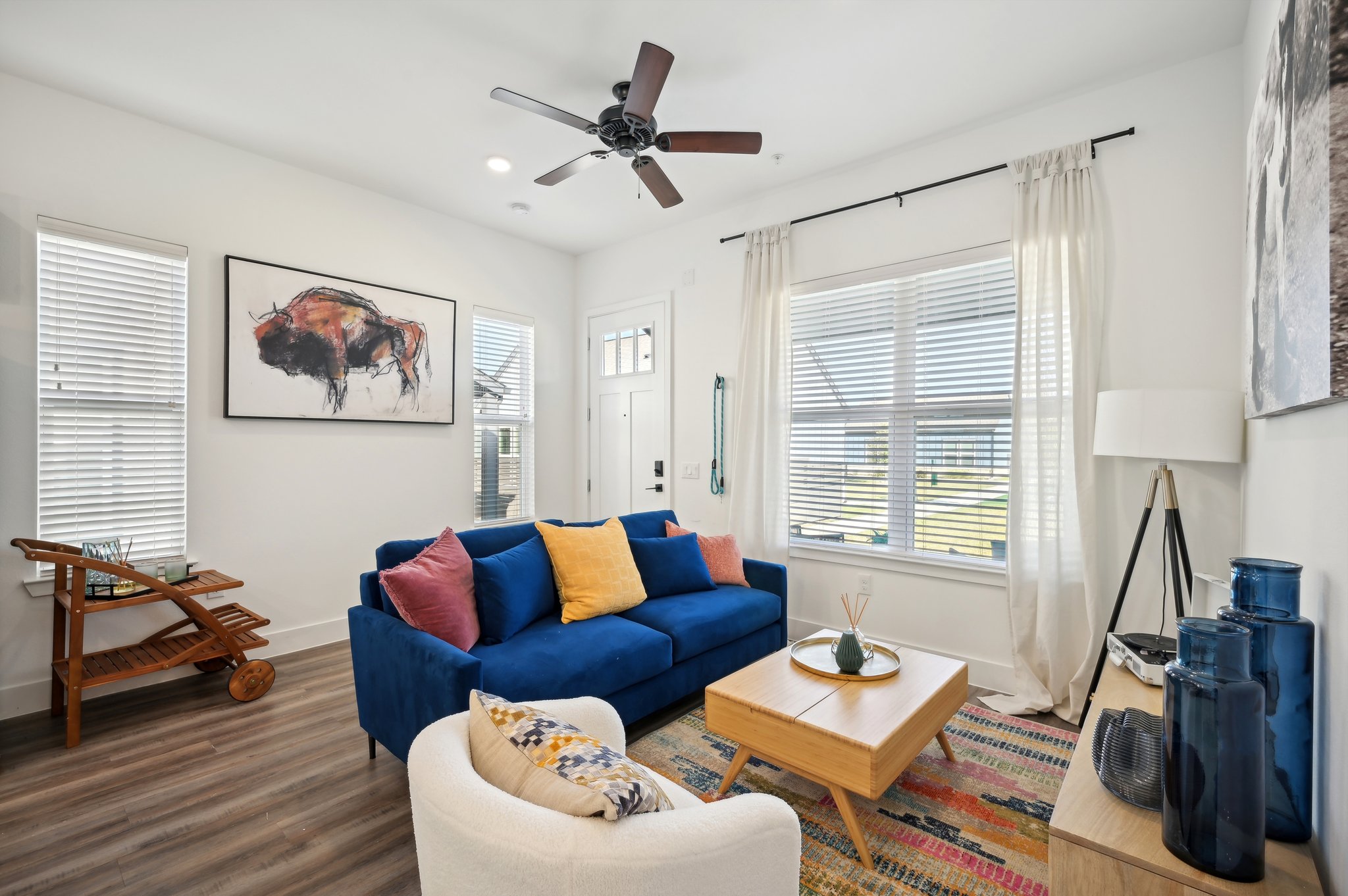 A living room with a blue couch and a wooden coffee table.