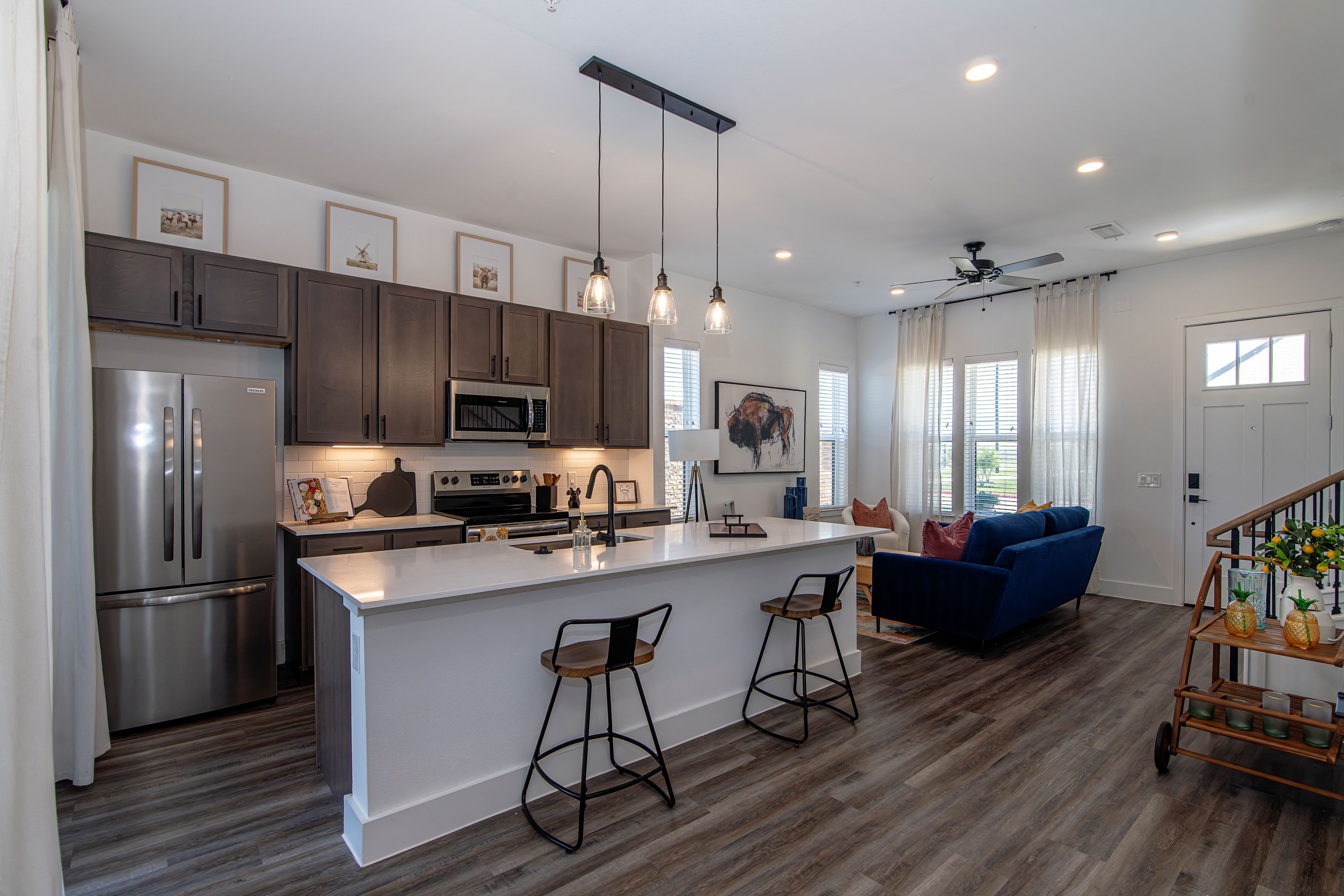 A kitchen with a white counter and a blue couch.