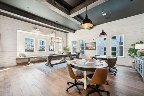 A modern dining room with a large table and chairs.