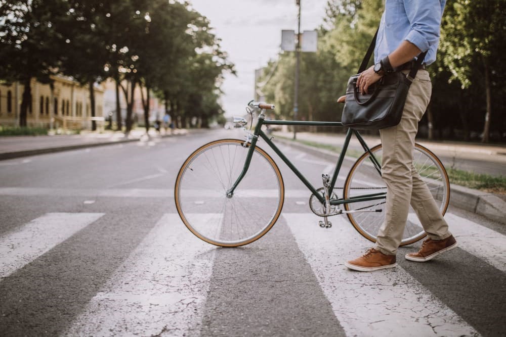 a man crossing the street with his bike on a crosswalk