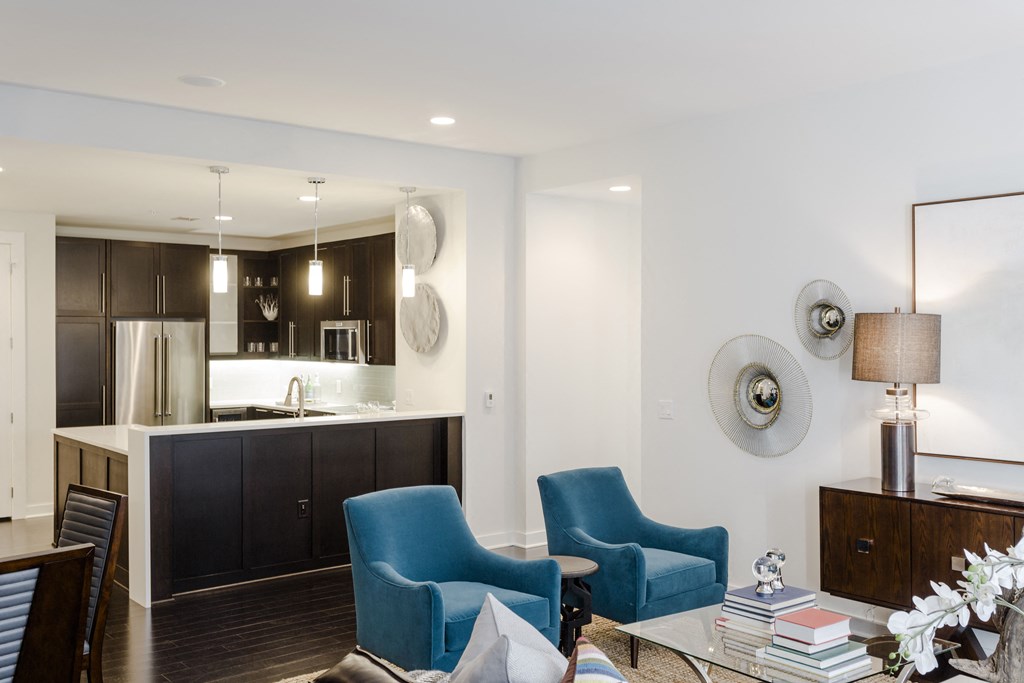 a living room and kitchen with blue chairs and a table