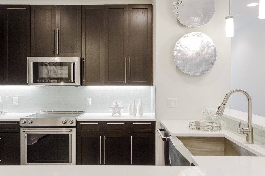 a kitchen with dark wood cabinets and a white counter top