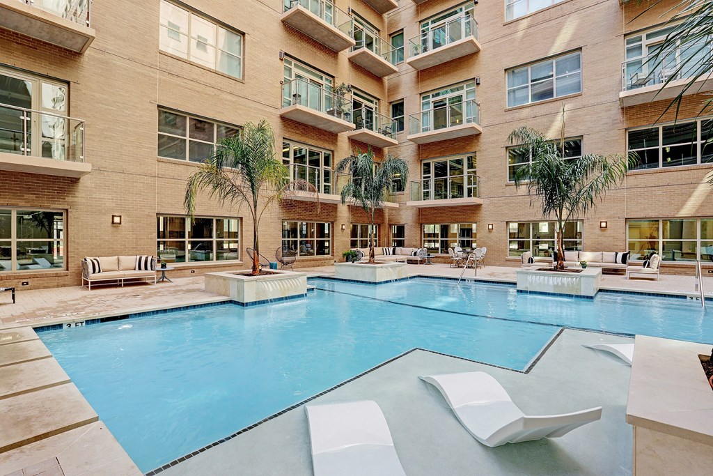 a large swimming pool in front of a large apartment building