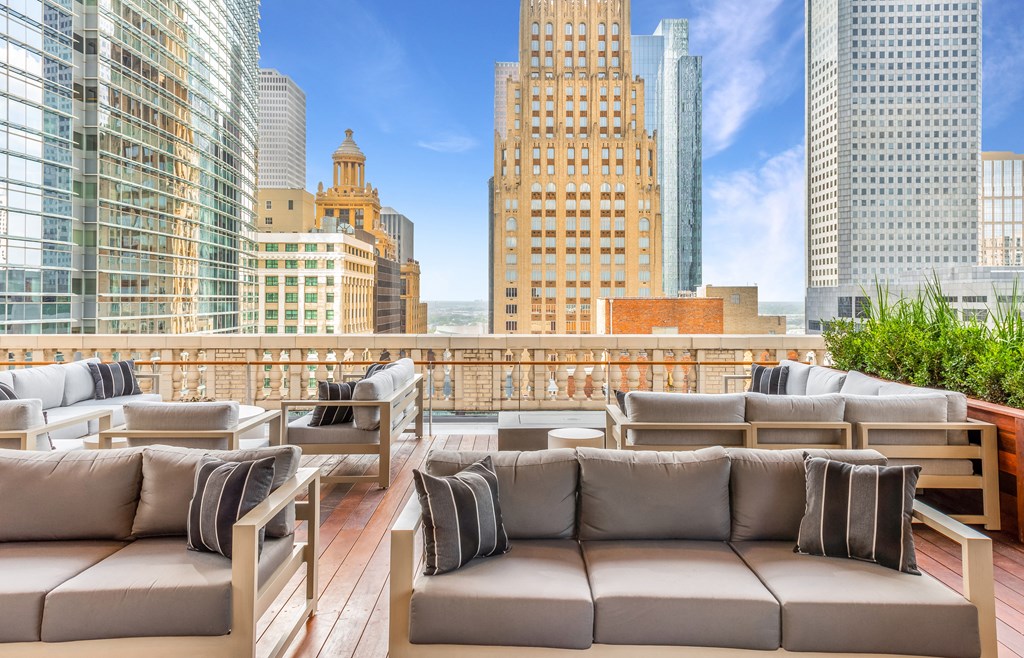 a rendering of a rooftop deck with couches and chairs