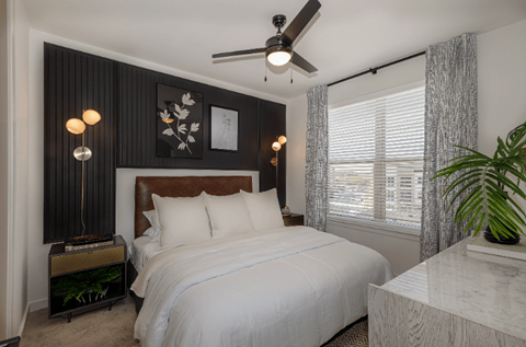 A bedroom with a large bed and a ceiling fan.