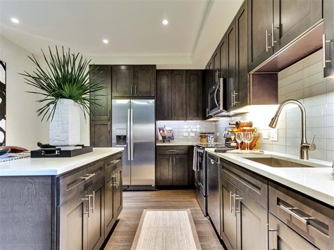 a large kitchen with stainless steel appliances and wooden cabinets