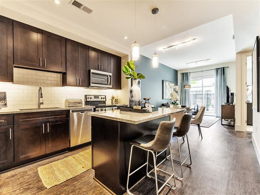 Large kitchen island with hardwood flooring and dark cabinets Luxury kitchen with island.