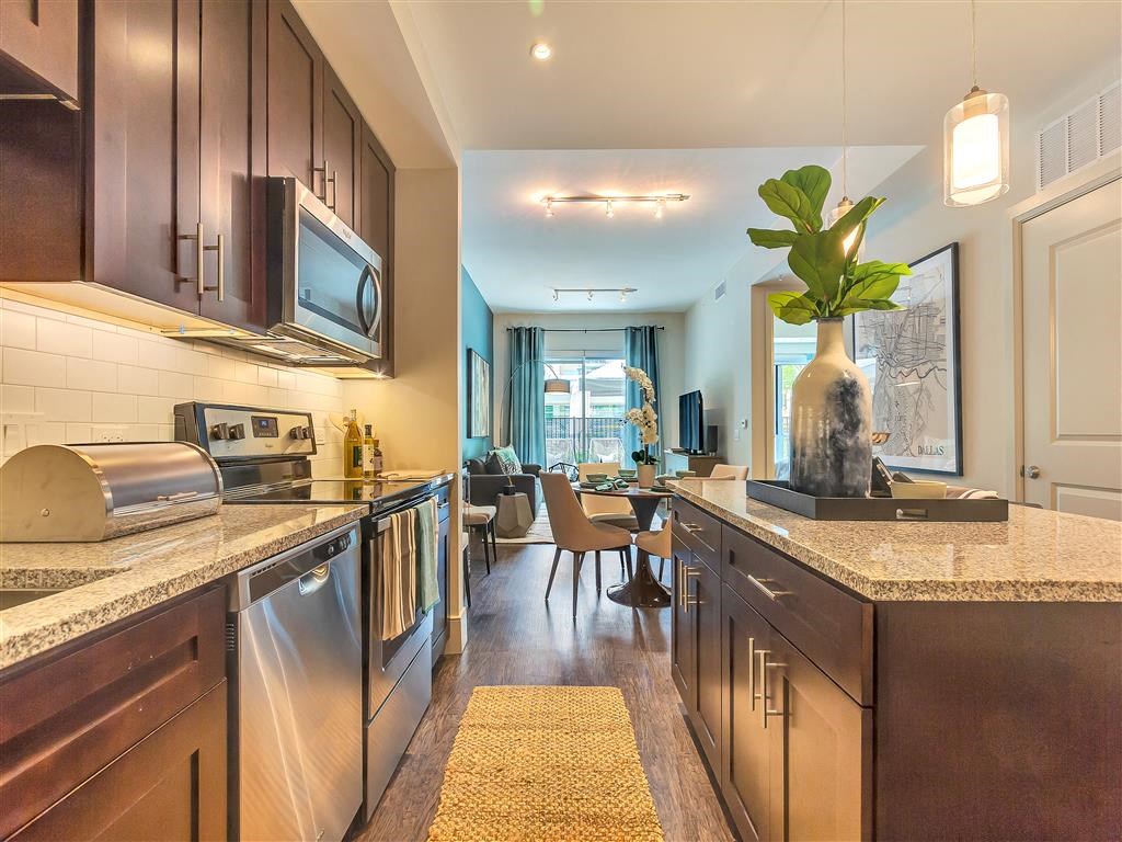 Large kitchen island with hardwood flooring and dark cabinets