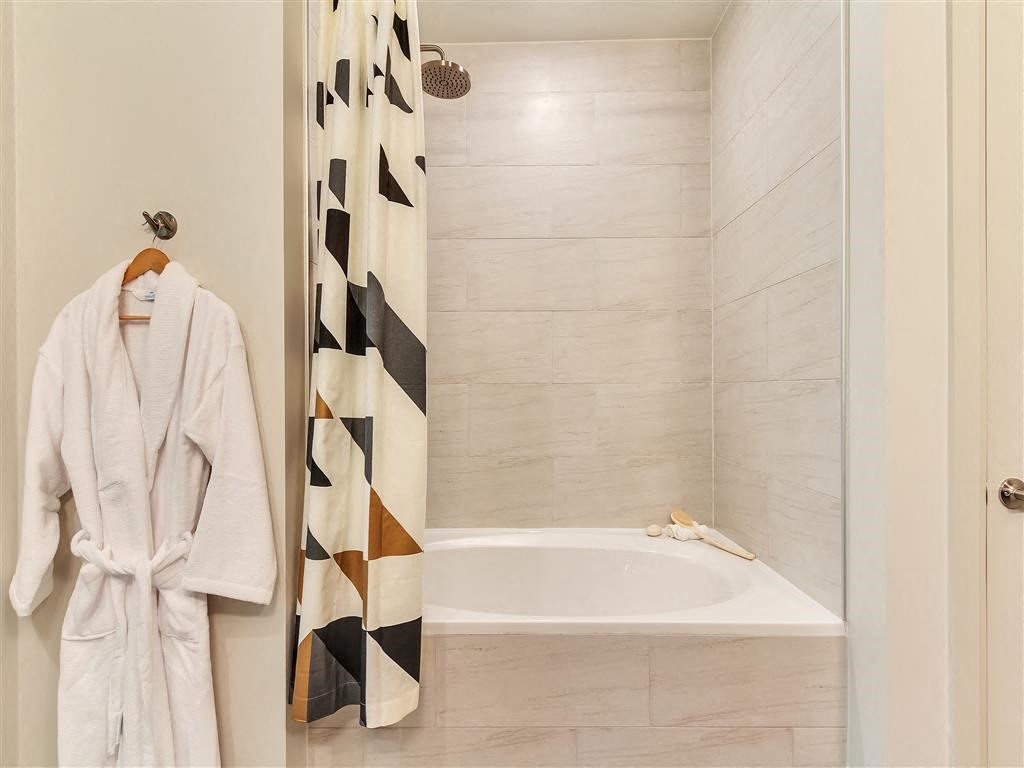 Large oval soaking bathtub with surrounding tile.