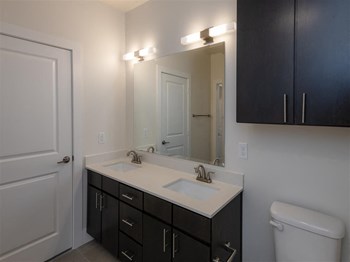 Bathroom with double vanity and addition storage cabinets.