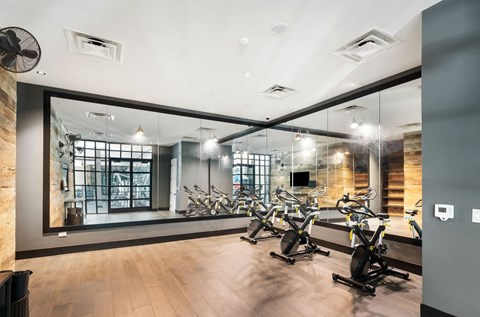 A gym with a mirror on the wall and exercise bikes  at Bridges at Flatiron, Broomfield, 80021