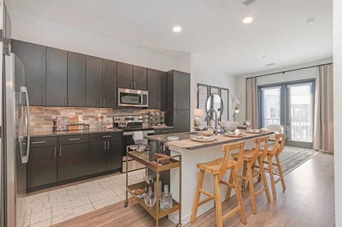 A modern kitchen with dark wood cabinets and a central island.