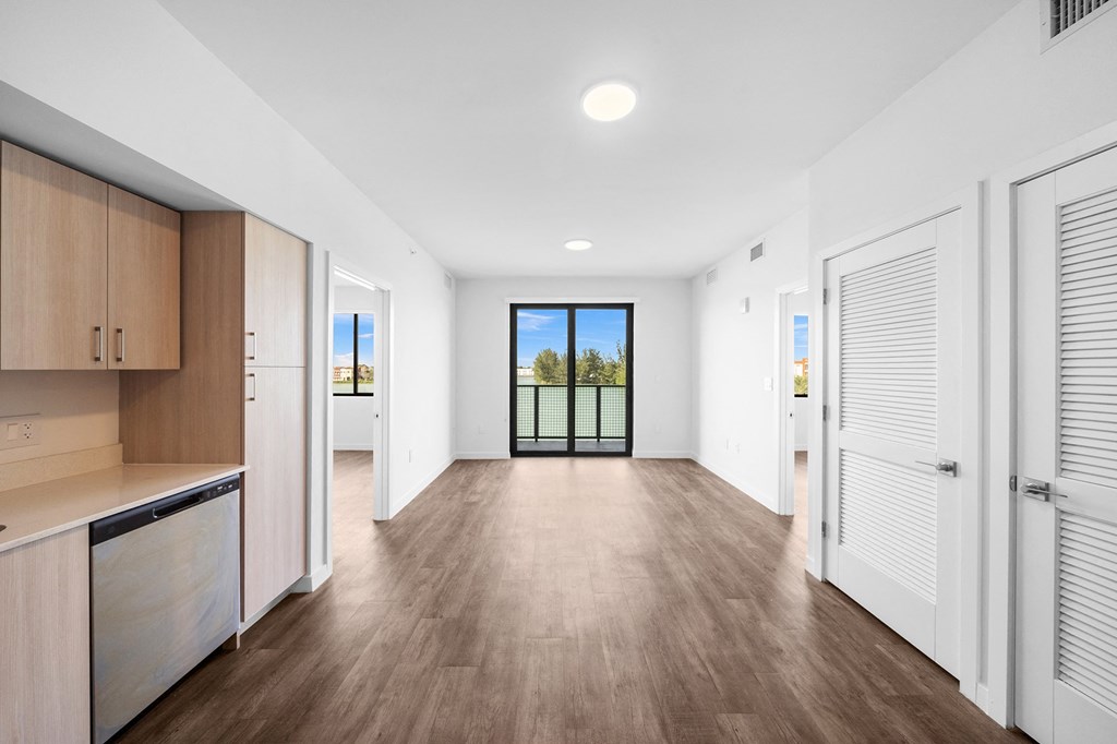 An empty living room with white walls and wood floors