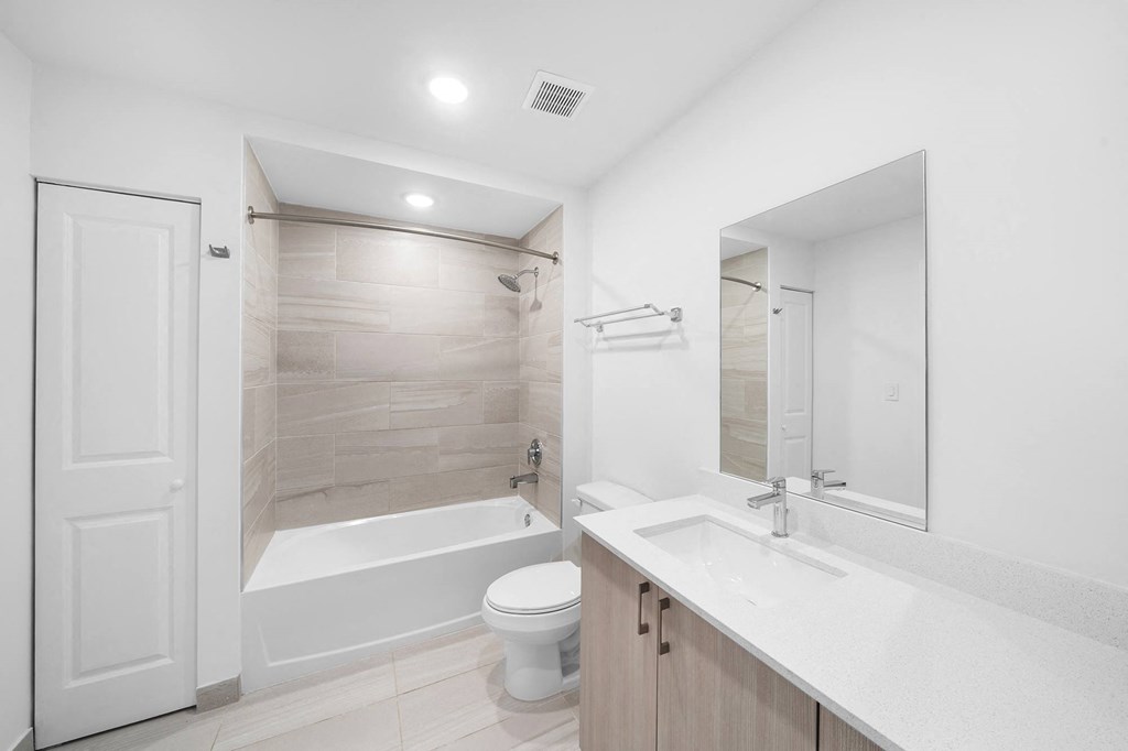 A bathroom with a sink toilet and a bath tub