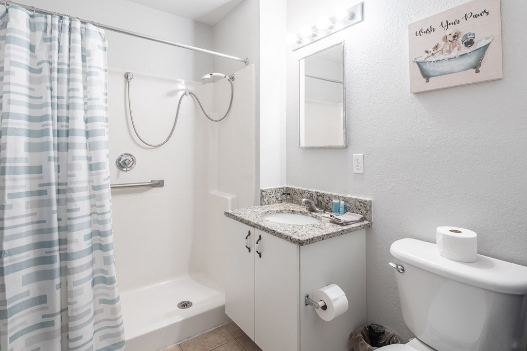 a bathroom with a shower and a sink and a toilet