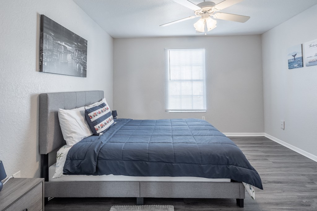 a bedroom with a bed and a ceiling fan