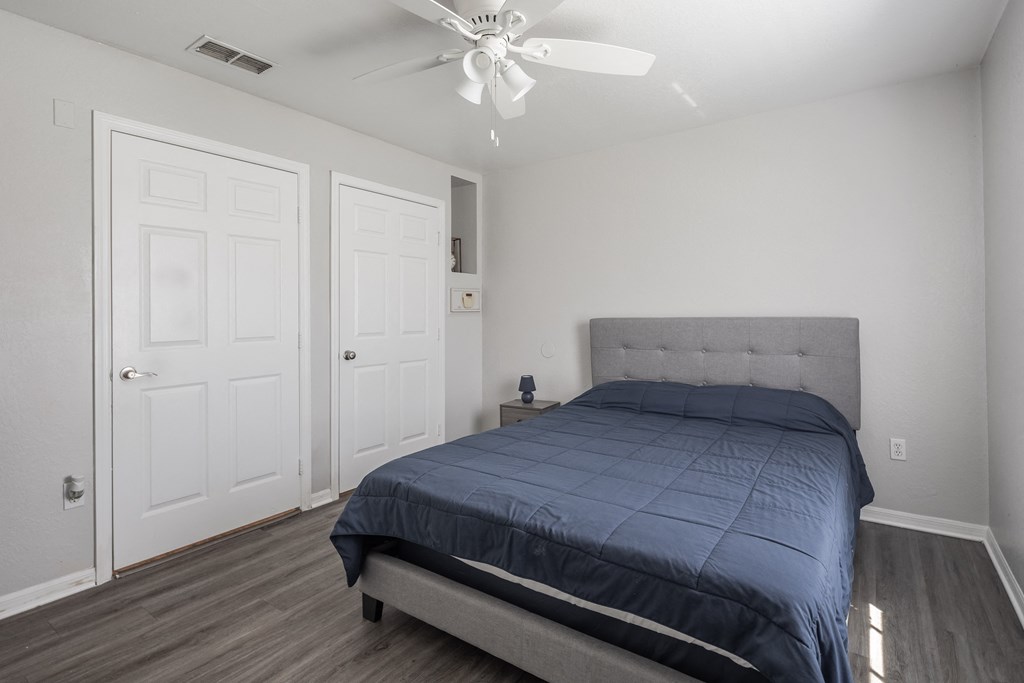a bedroom with a bed and a ceiling fan