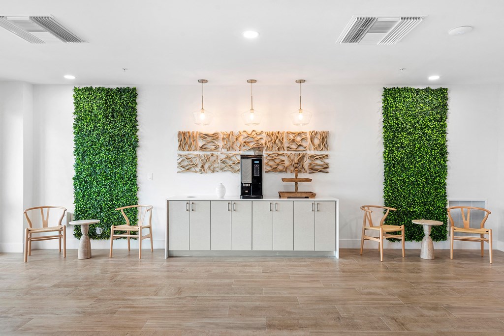 A reception area with a white wall covered in green plants