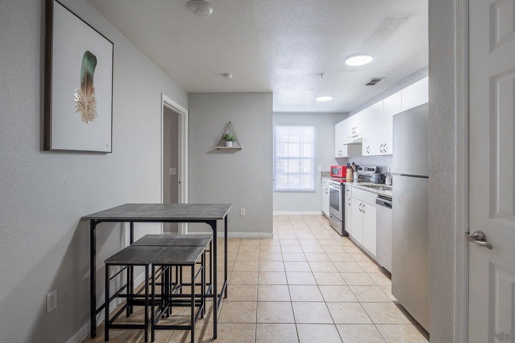 an empty kitchen with a dining table and stools