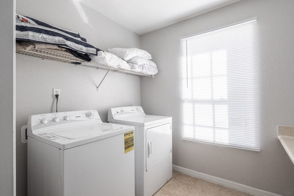 the private laundry room has a washer and dryer and a window