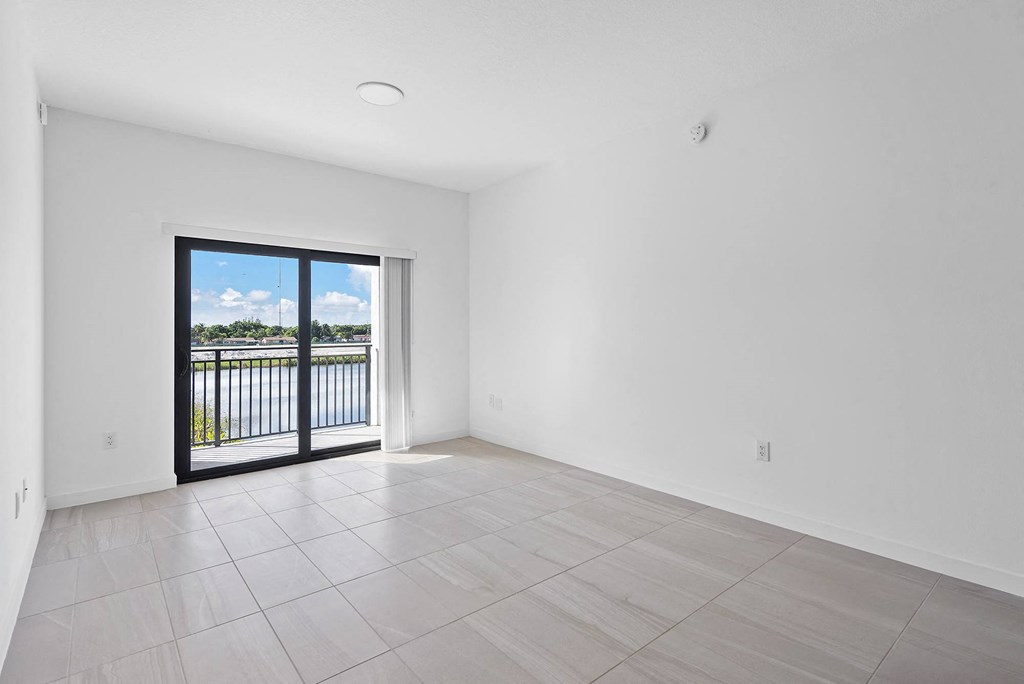 a bedroom with a large window and a door that leads to a balcony