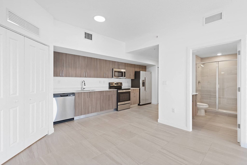 a kitchen with wooden cabinets and white walls