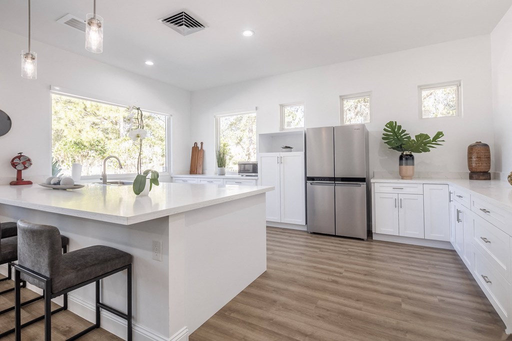 a kitchen with a large island and a stainless steel refrigerator